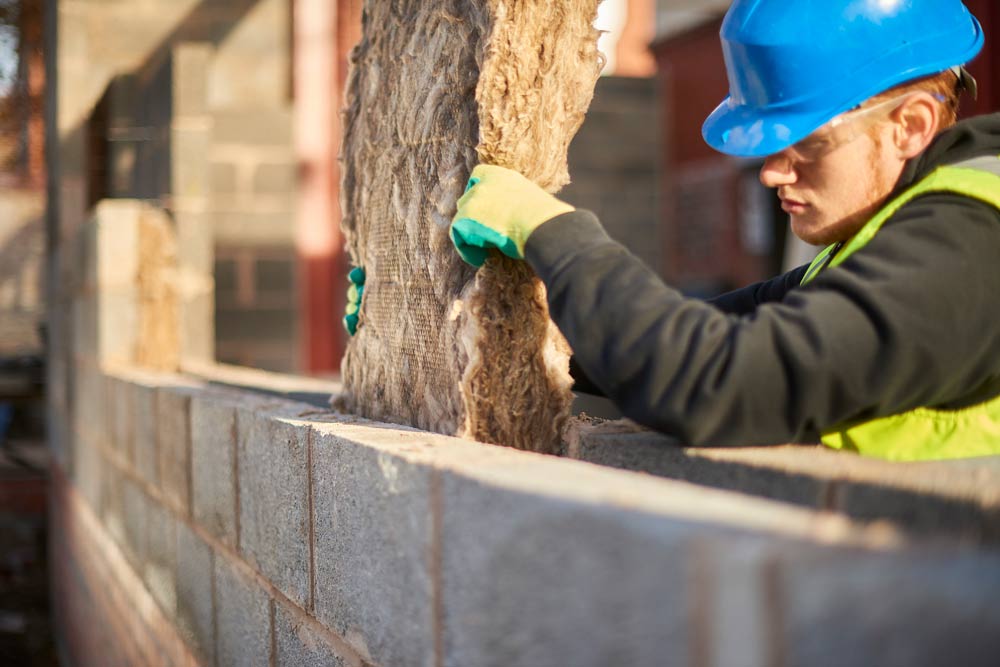 WADE BUILDING SUPPLIES | BUILDERS HAT SAT ON CAVITY WALL SHOWING WHERE INSULATION HAS BEEN FITTED