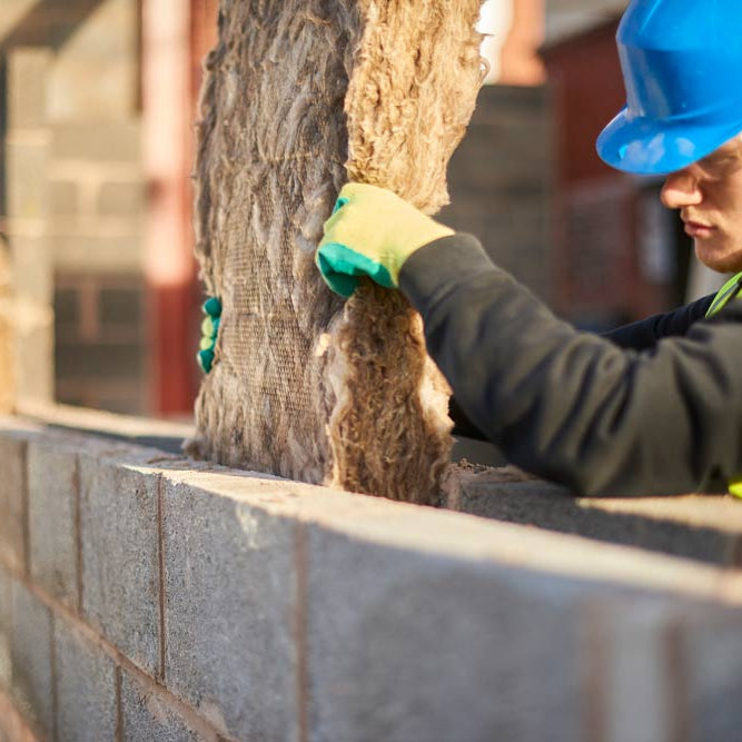 WADE BUILDING SUPPLIES | BUILDERS HAT SAT ON CAVITY WALL SHOWING WHERE INSULATION HAS BEEN FITTED